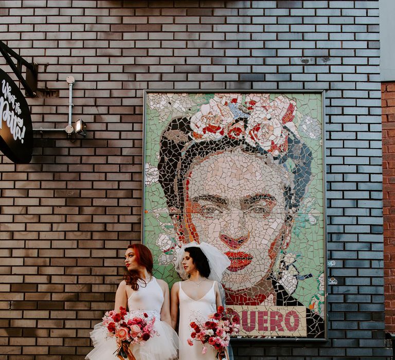 Manchester elopement with two brides in a high low layered tulle skirt wedding dress and a satin slip wedding dress with long bow veil 