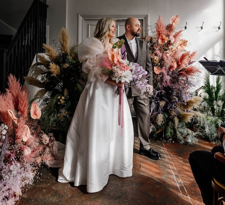 Colourful modern wedding at Floral Hall, London with pastel colour flowers, bride in a princess wedding dress and groom in a double breasted blazer 