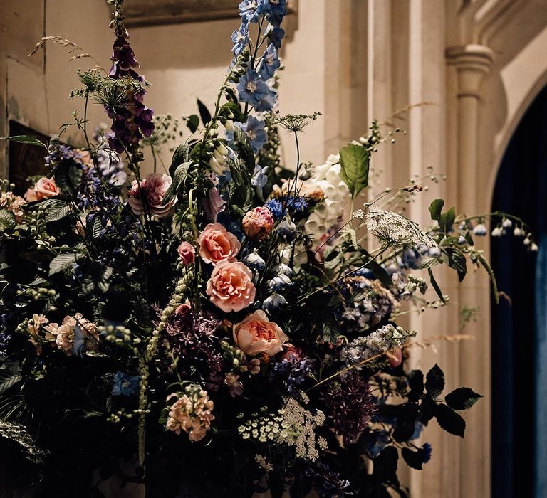 Pink, blue and white wedding flowers decorate the church 