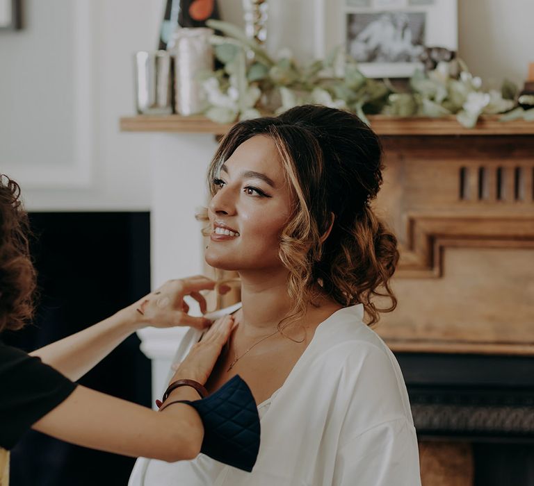 Bride in white satin feather getting ready robe getting ready for London wedding