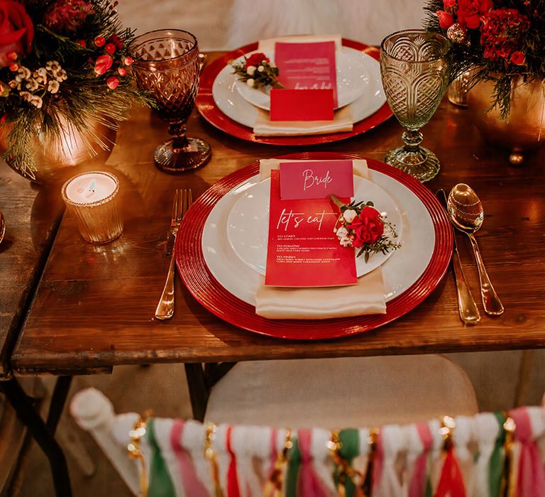 Rustic wedding tablescape with hot pink plates, hot pink place names, gold candleholders, gold vase centrepieces and gold cutlery 