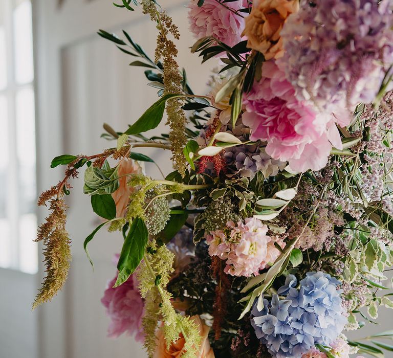 Seasonal pastel florals for wedding archway 