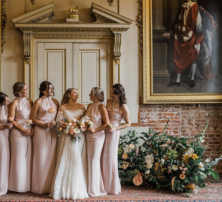 The bridal party with the bridesmaids in pink halter neck bridesmaid dresses with the bride at the country house wedding 