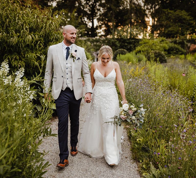 Bride in pretty appliqué bridal gown with the groom at their summer wedding 