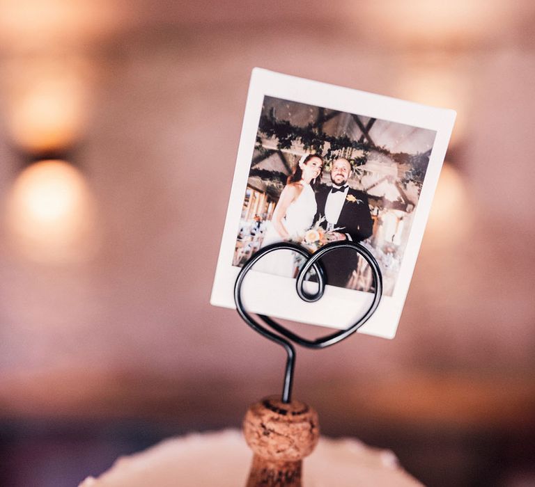 Cork wedding cake topper with a polaroid of the bride and groom on buttercream wedding cake