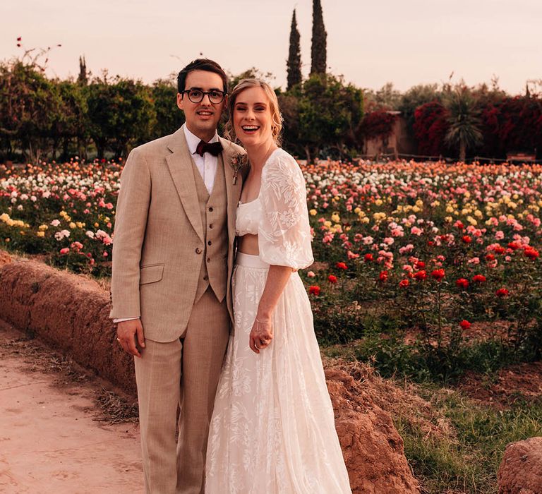 Golden hour wedding portrait of the bride and the groom next to fields of colourful flowers 