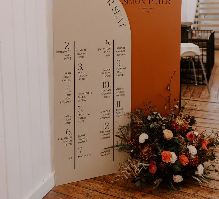 Orange and beige wedding seating chart that was DIY'd by the couple 