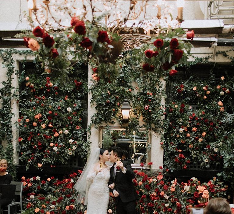 The bride and groom cheers together after their ceremony together in their classic wedding outfits 