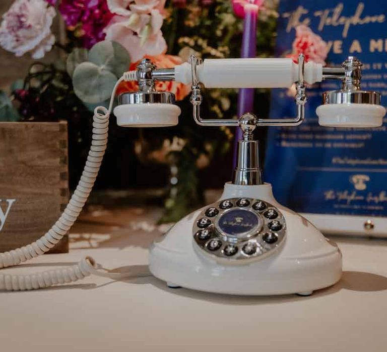 Wedding rotary phone guestbook on white wedding tablecloth at Elmore Court Gloucestershire