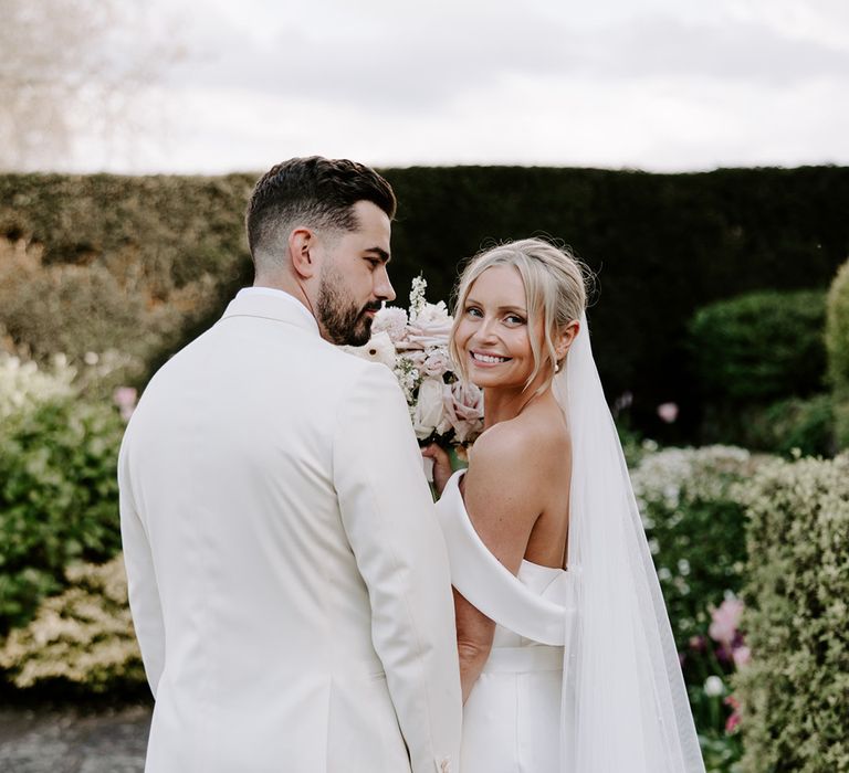 Groom in white suit jacket with bride in off the shoulder dress and classic veil 