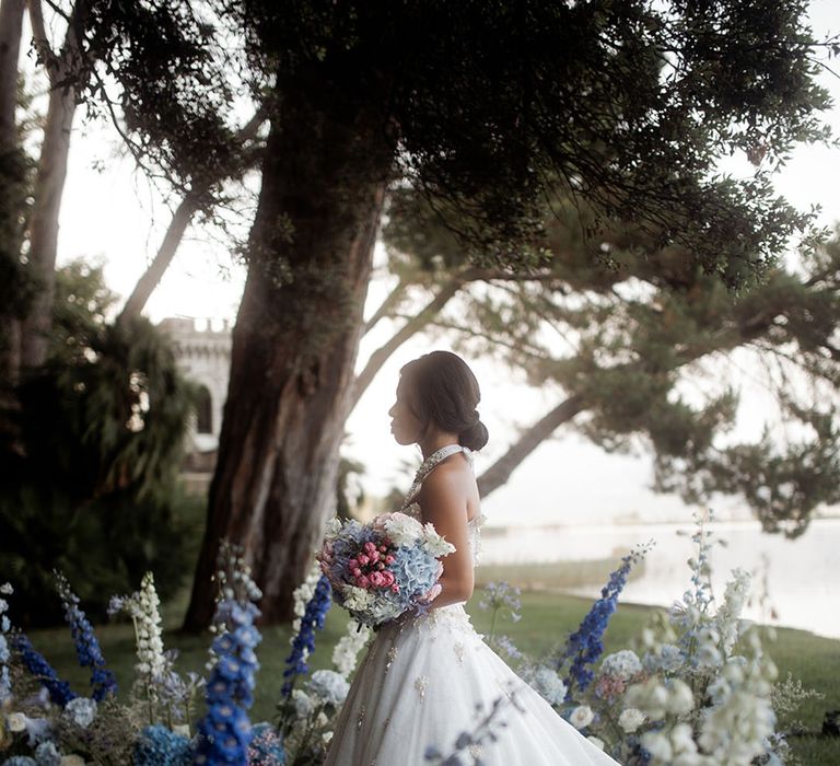 Blue wedding flowers decorating the altar with bride walking through in princess wedding dress 