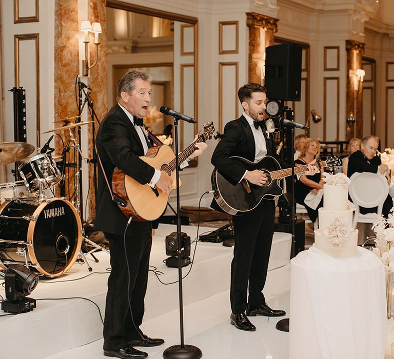 Groom and father of the groom perform at the wedding together 