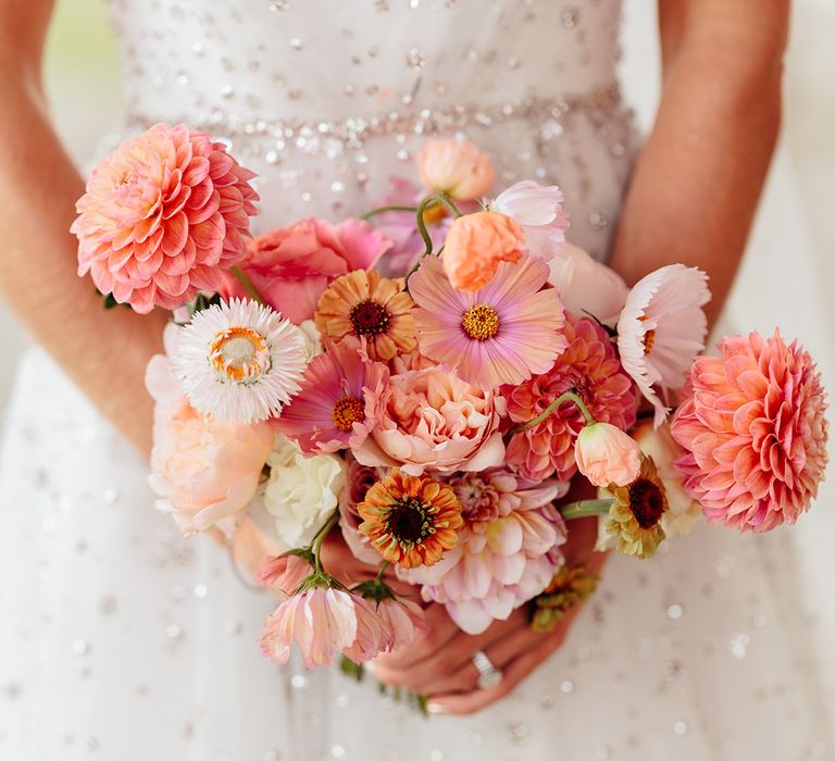 Bride holding pink and white wedding bouquet with sweet pea, dahlias, and cosmos 