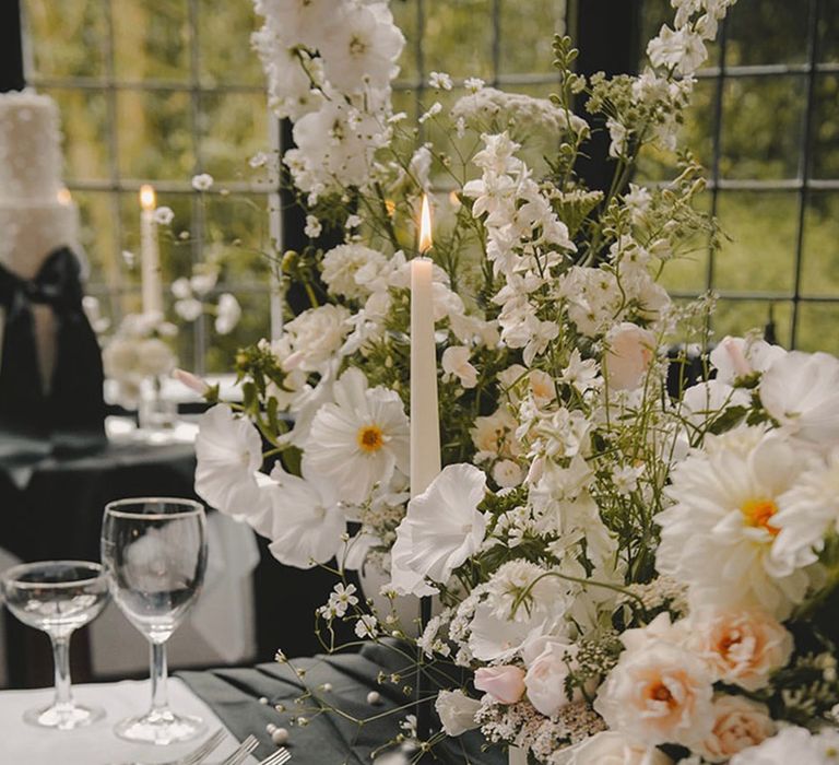 All white wedding flowers lining the tables with hyacinth and roses 