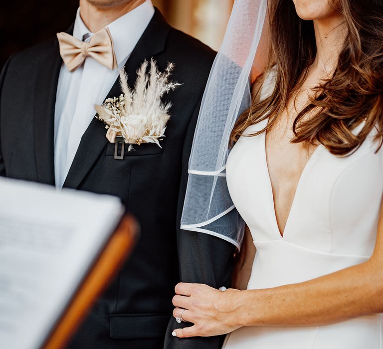 Bride and groom linking arms at their mansion wedding 