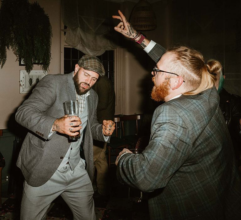 Wedding guests in grey suits dancing at the wedding reception 