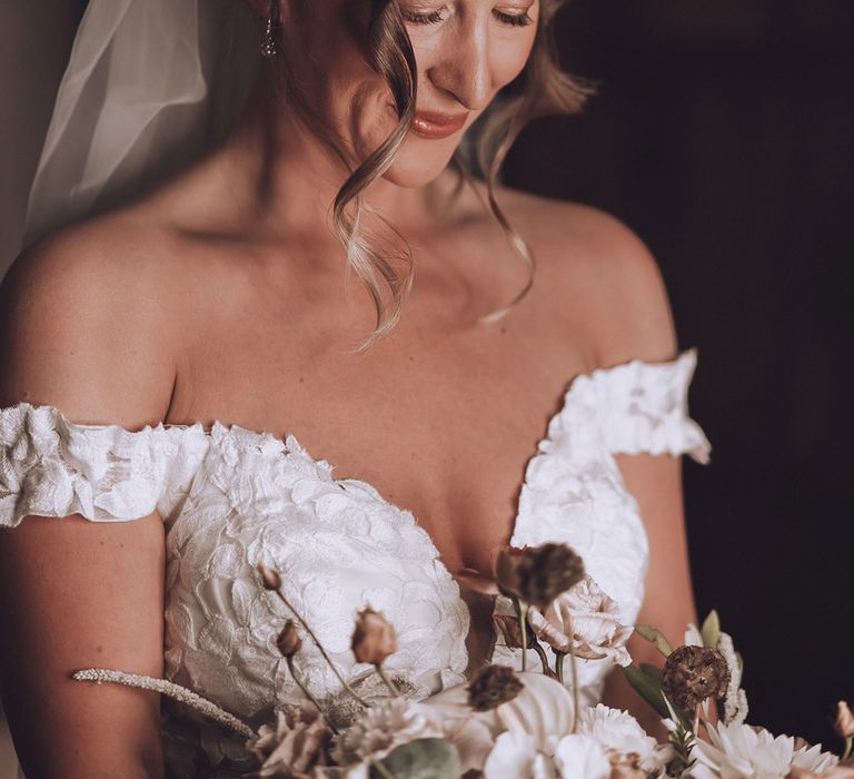 Bride in flower off the shoudler wedding dress for the bride with her hair in updo with wedding veil 