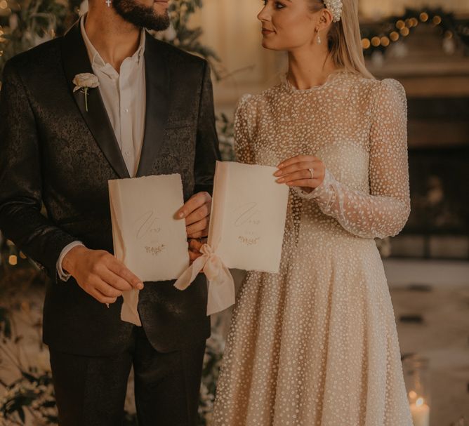 Bride and groom holding their vow books at intimate wedding