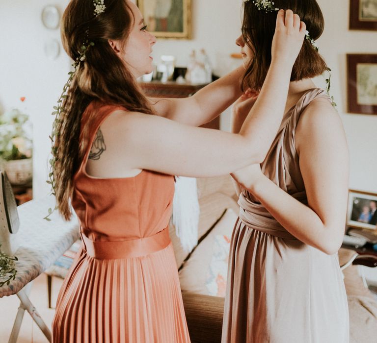 Bridesmaids putting on gypsophila flower crowns 