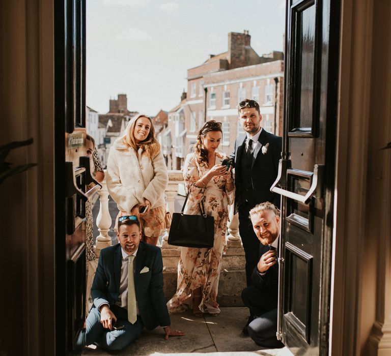 Wedding guests watching the socailly distanced wedding from outside 