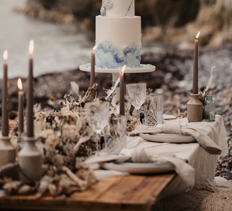 Geode wedding cake on a grazing table with candles 