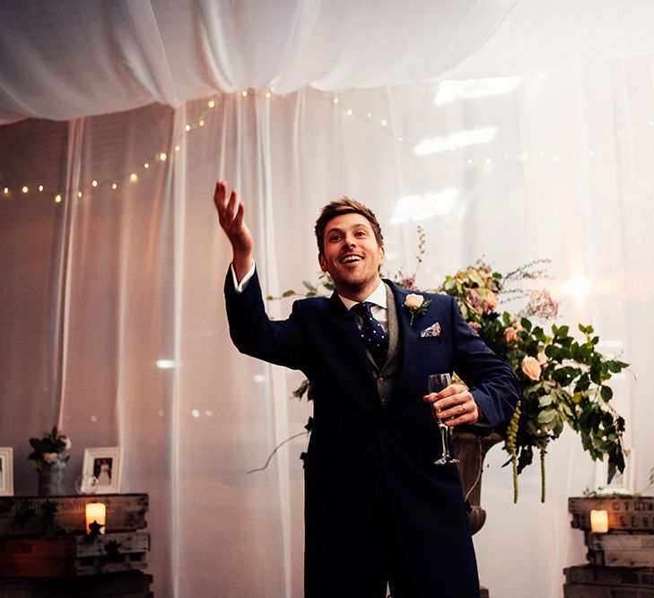 Newly-wed groom wearing navy suit and polka dot tie 