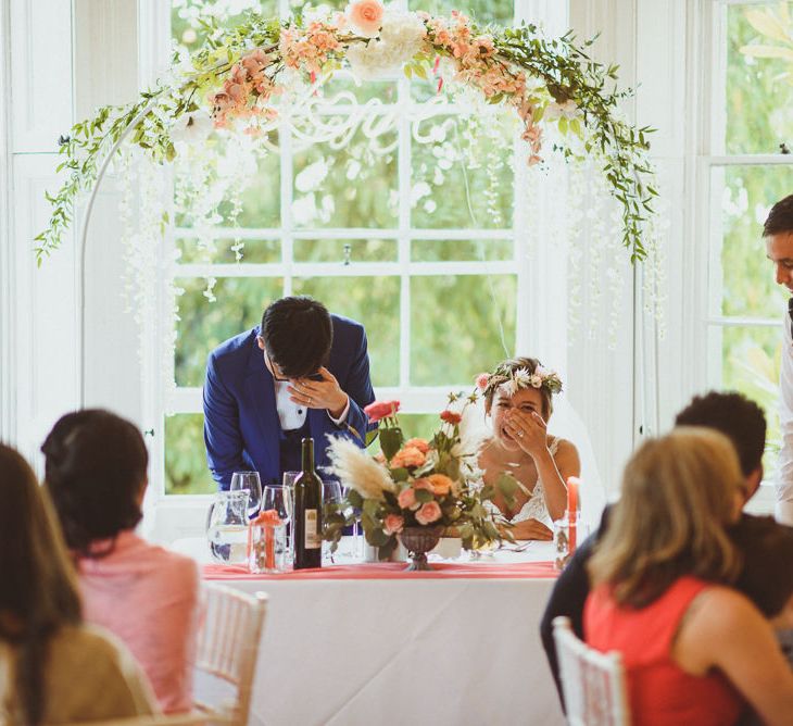 Bride and groom laughing during the wedding speeches 