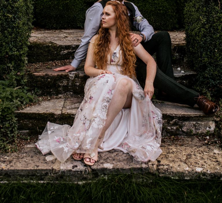 Bride & groom pose outside with bride wearing appliqué wedding dress