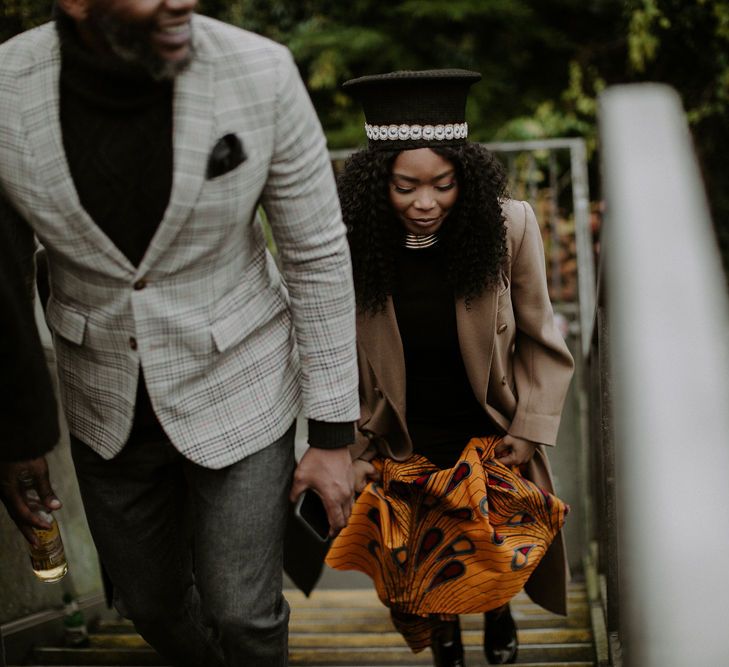 Bride in Zulu hat walking up some steps 