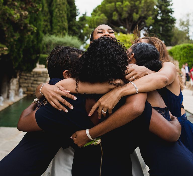 Group hug between the brides and her bridesmaids