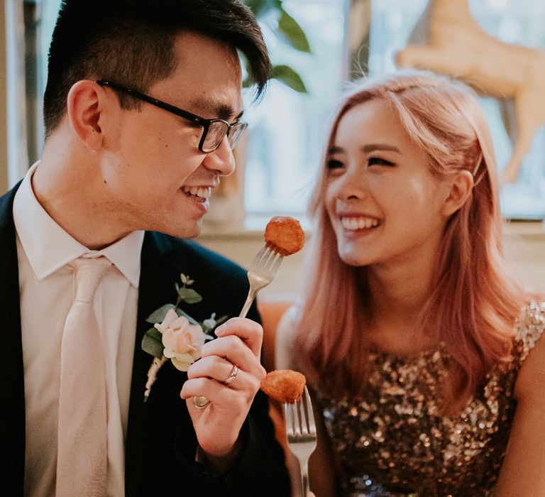 Bride and groom enjoying cheese croquettes after their intimate Town Hall wedding 