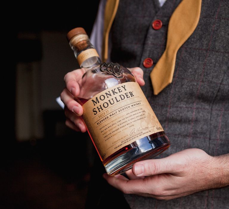 Groom holding monkey shoulder scotch whisky 