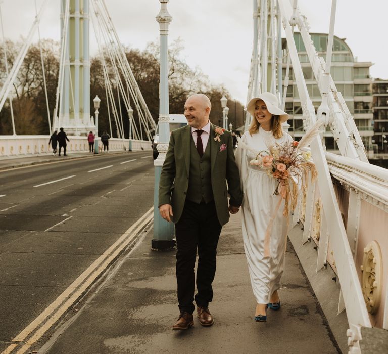 Bride & groom walk together on the day of their wedding in London