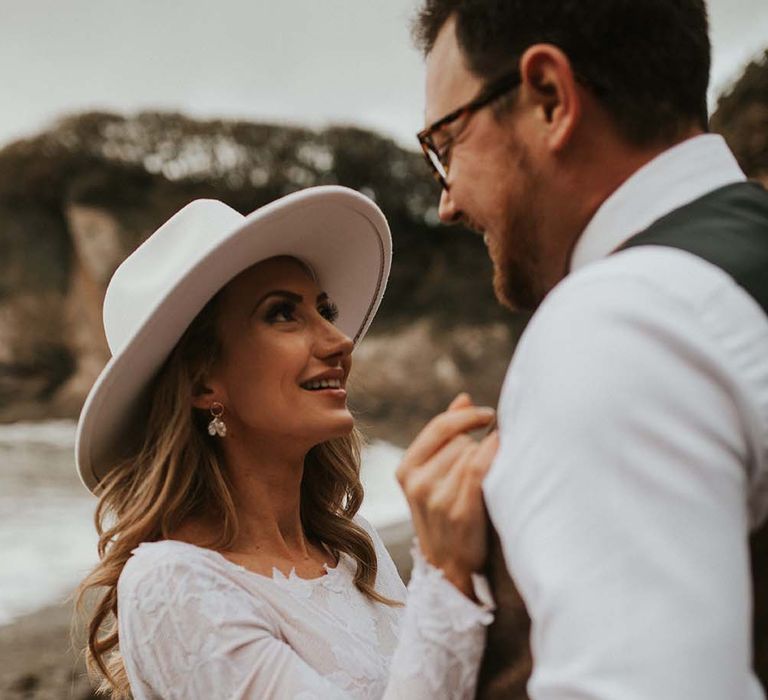 Boho bride in a white Fedora hat and dangly earrings