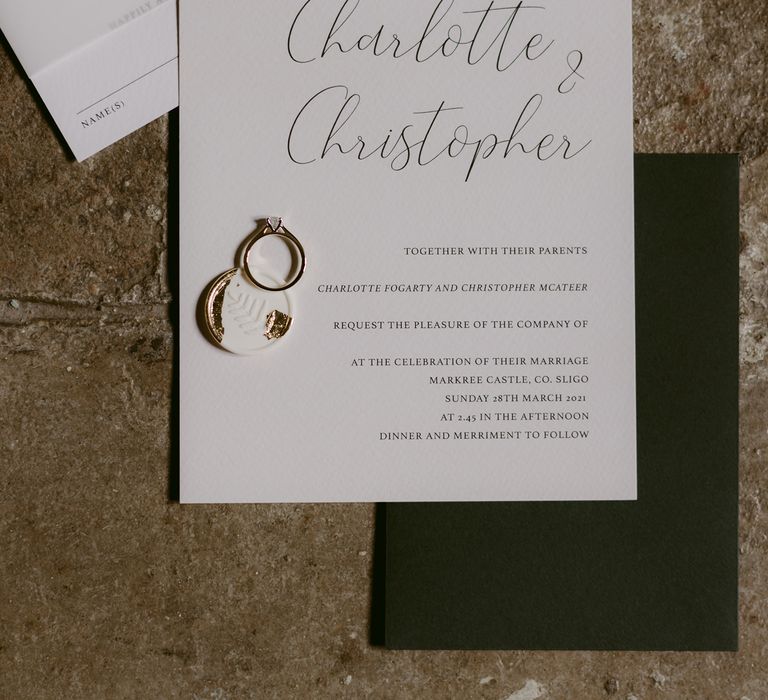 Wedding stationery in classic white with accents of gold and diamond wedding ring to the side