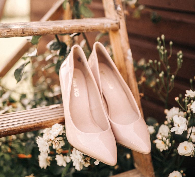 Neutral wedding shoes on a step ladder.