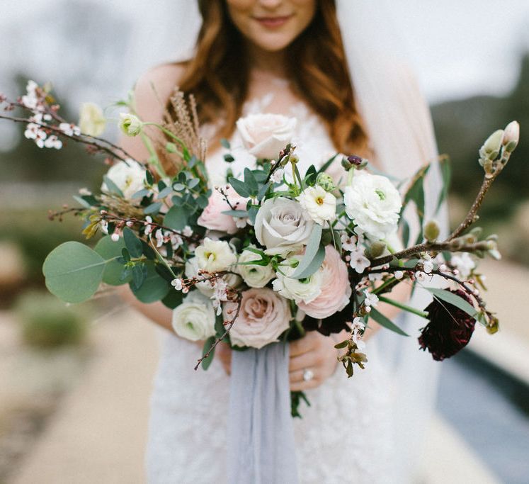 Romantic blush pink and white rose wedding bouquet with foliage 