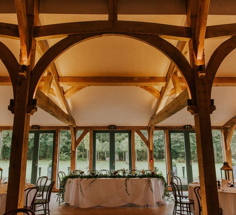 Hazel Gap Barn wedding reception with top table decorated with foliage 