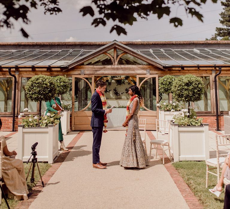 Bride & groom stand outside Gaynes Park during wedding ceremony | Joshua Gooding Photography