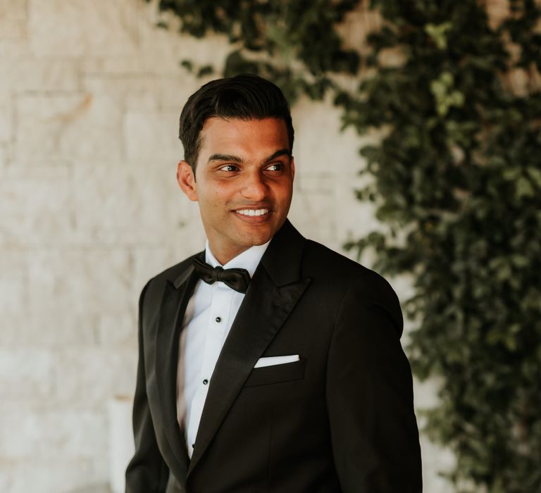 Groom smiles on his wedding day as he wears black tie attire and looks dapper | Hannah MacGregor Photo & Film