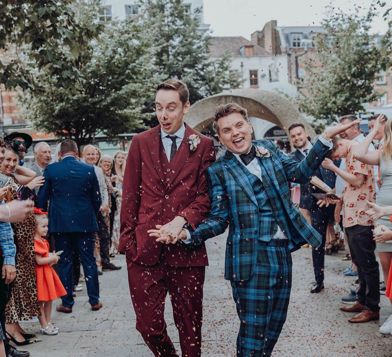 Grooms celebrate as they walk through confetti on their wedding day | Kim Williams Weddings