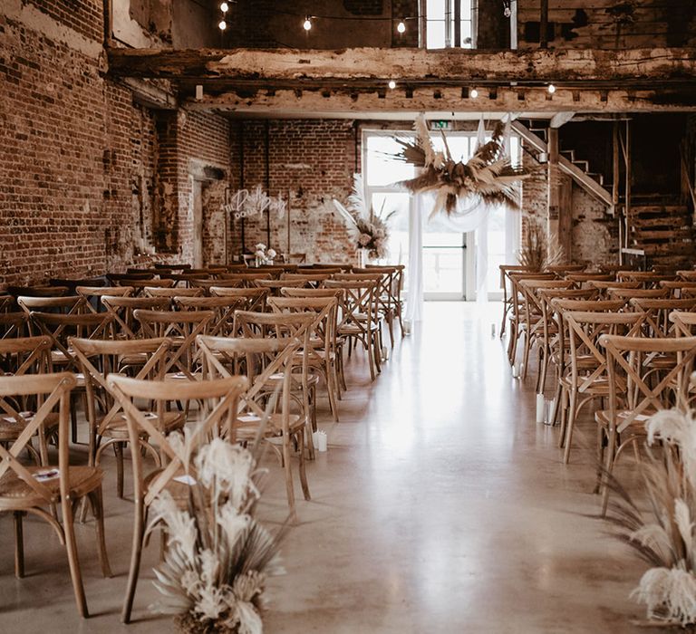 Rustic aisle at Godwick Great Barn complete with dried floral installations 