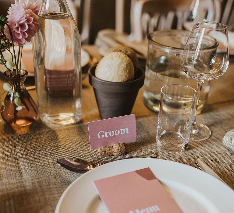 Wedding tablescape complete with pale pink stationery on wooden table