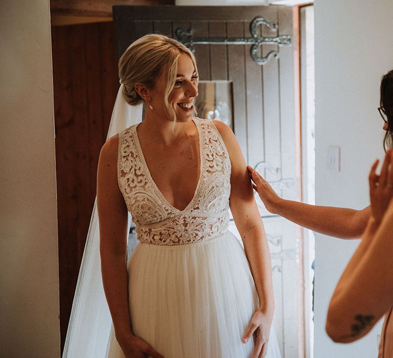 Lace detail wedding dress with pinned bridal undo and veil