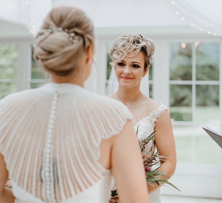 Bride smiles at her wife to be on their wedding day