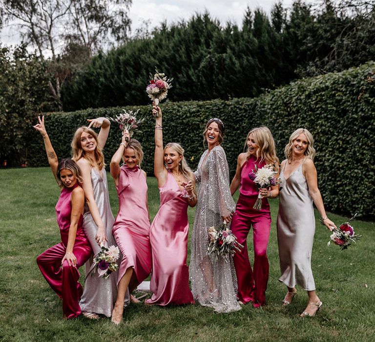 Bridal party portrait with bride in a silver sequin wedding dress with her bridesmaids in satin dresses and jumpsuits 