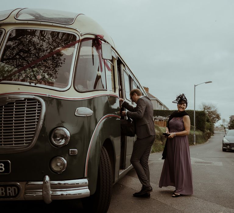 Wedding guests enter vintage bus for rustic wedding day