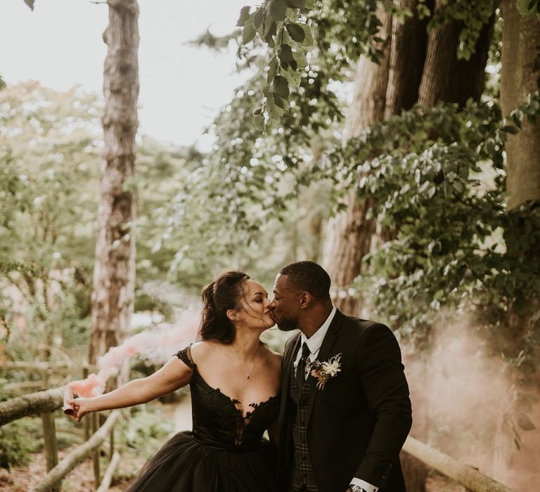 Bride & groom kiss one another outdoors after their wedding ceremony