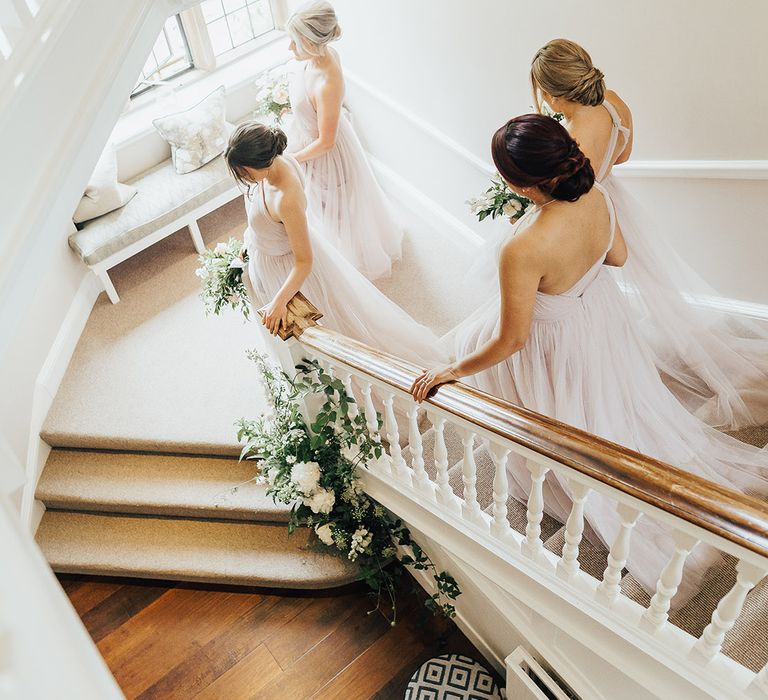 Bridal party walking down the stairs in TH&TH Tulle, soft pink bridesmaid dresses 