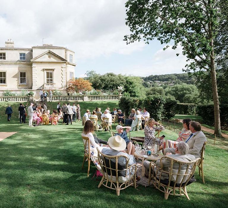 Country style outdoor English wedding at Georgian house in Bath with wedding guests mingling outside tipi reception